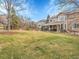 Serene backyard with green lawn, mature trees, and a view of neighboring homes and natural landscape at 10062 Eagle Valley Way, Highlands Ranch, CO 80129