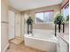 Bright bathroom featuring a garden tub, glass enclosed shower, and neutral decor at 10062 Eagle Valley Way, Highlands Ranch, CO 80129