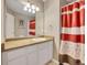 Bathroom with a single sink, white cabinets and red accented shower curtain at 10062 Eagle Valley Way, Highlands Ranch, CO 80129