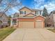 Two-story home featuring brick accents, a three-car garage, and a well-maintained lawn at 10062 Eagle Valley Way, Highlands Ranch, CO 80129