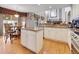 Bright kitchen features an island, granite countertops, wood floors, and a cozy breakfast nook at 10062 Eagle Valley Way, Highlands Ranch, CO 80129