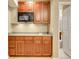 Small kitchenette with cabinets, microwave, and sink; bathroom in the background at 10062 Eagle Valley Way, Highlands Ranch, CO 80129