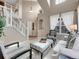 Bright and airy living room with soaring ceilings, large windows, and a staircase, offering a grand and inviting atmosphere at 10062 Eagle Valley Way, Highlands Ranch, CO 80129