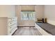 Sunlit bedroom with built in bed, gray wood floors, and a large window overlooking greenery at 12818 Ironstone Way # 101, Parker, CO 80134