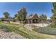 Community clubhouse exterior featuring lush landscaping, green grass, and pergola details at 12818 Ironstone Way # 101, Parker, CO 80134