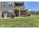Exterior shot of home with a covered porch, green lawn, landscaping, and unit number 12818 at 12818 Ironstone Way # 101, Parker, CO 80134