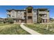 Multi-level condo building showing brick accents, and well-maintained green lawn at 12818 Ironstone Way # 101, Parker, CO 80134