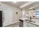 Kitchen features stainless steel appliances, white cabinets and countertops, and hardwood floors at 12818 Ironstone Way # 101, Parker, CO 80134