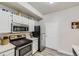 Well-lit kitchen featuring stainless steel appliances, white cabinets, and wood flooring at 12818 Ironstone Way # 101, Parker, CO 80134
