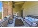 Relaxing outdoor patio with wicker seating, a glass table, and a partial brick enclosure at 12818 Ironstone Way # 101, Parker, CO 80134
