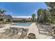 Community pool area featuring lounge chairs, surrounding trees, and clubhouse building in the background at 12818 Ironstone Way # 101, Parker, CO 80134