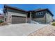 Exterior of home with gray concrete driveway, attached garage, and garden level entrance at 3375 New Haven Cir, Castle Rock, CO 80109