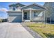 Charming two-story home with a welcoming porch, well-manicured lawn, and attached garage at 5805 Red Barn Ave, Mead, CO 80504