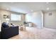 Bright, carpeted living room featuring a comfortable seating area and a dedicated workspace at 5805 Red Barn Ave, Mead, CO 80504