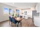 Bright dining area with an open layout to the kitchen, with a sliding glass door to a deck at 5805 Red Barn Ave, Mead, CO 80504