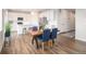 Open-concept kitchen and dining area with modern white cabinets and wood-style flooring at 5805 Red Barn Ave, Mead, CO 80504