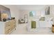 Bright bedroom features a large window, white linens with olive green accents, and a dresser at 6602 S Vance St, Littleton, CO 80123