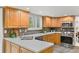 Well-lit kitchen boasts wood cabinetry, mosaic backsplash, and modern stainless appliances at 6602 S Vance St, Littleton, CO 80123