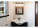 Charming half bathroom featuring a sleek sink, dark wood accents, and a window for natural light at 6323 W 85Th Ave, Arvada, CO 80003