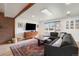 Cozy living room featuring hardwood floors, a brick accent wall, a large window, and comfortable seating at 6323 W 85Th Ave, Arvada, CO 80003