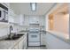 Efficient white kitchen with stone countertops and open access to living area at 9995 E Harvard Ave # 246, Denver, CO 80231