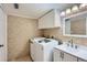 Laundry room with updated washer, dryer, cabinet, and sink at 9995 E Harvard Ave # 246, Denver, CO 80231