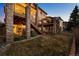 Backyard view showing multi-tiered decks with stone supports and a well-maintained lawn at 2577 Shadecrest Pl, Highlands Ranch, CO 80126