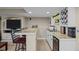 Finished basement has a bar with seating, wine racks and a mini fridge at 2577 Shadecrest Pl, Highlands Ranch, CO 80126
