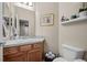 Powder room featuring a vanity with decorative tiling, a toilet, and stylish decor at 2577 Shadecrest Pl, Highlands Ranch, CO 80126