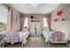 A sweet bedroom with two beds, pink curtains, and butterfly decor at 2577 Shadecrest Pl, Highlands Ranch, CO 80126