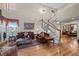 Elegant living room featuring a cozy fireplace, hardwood floors, and a staircase at 2577 Shadecrest Pl, Highlands Ranch, CO 80126