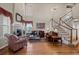 Elegant living room featuring a cozy fireplace, hardwood floors, and a staircase at 2577 Shadecrest Pl, Highlands Ranch, CO 80126
