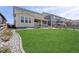 Expansive backyard featuring a lush lawn, stone accents, and an inviting patio area perfect for outdoor gatherings at 21650 E Tufts Cir, Aurora, CO 80015