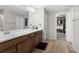 Dual vanity bathroom featuring modern fixtures and wood-look floors, with a closet view at 21650 E Tufts Cir, Aurora, CO 80015