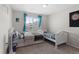Charming bedroom featuring two twin beds, a large window, and neutral decor at 21650 E Tufts Cir, Aurora, CO 80015