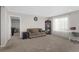 Comfortable living room with plush sofa, built in shelving, and natural light from sheer window coverings at 21650 E Tufts Cir, Aurora, CO 80015