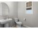 This powder room features a pedestal sink and a window letting in ample natural light at 21650 E Tufts Cir, Aurora, CO 80015