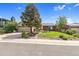 A charming home boasts a well-maintained lawn, mature trees, and a welcoming facade at 1982 S Truckee St, Aurora, CO 80013
