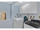 Laundry room with modern washer and dryer units, and white cabinets for storage at 1982 S Truckee St, Aurora, CO 80013