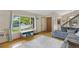 Sunlit living room with hardwood floors, a plush gray sofa, and a large window at 1982 S Truckee St, Aurora, CO 80013