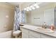 Well-lit bathroom featuring a vanity, modern lighting, and a shower-tub combination with a stylish curtain at 9392 Crestmore Way, Highlands Ranch, CO 80126