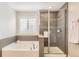 Bright bathroom with a soaking tub and separate shower with modern glass enclosure at 21851 E Tallkid Ave, Parker, CO 80138
