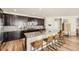 Modern kitchen with dark cabinets, quartz countertops, and a large center island with bar seating at 21851 E Tallkid Ave, Parker, CO 80138