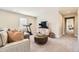 Bright living room featuring neutral walls, plush carpeting, stylish decor, and a treadmill for home workouts at 21851 E Tallkid Ave, Parker, CO 80138