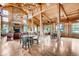 Spacious living room with vaulted wood ceilings, chandeliers, a stone fireplace, and ample natural light at 21851 E Tallkid Ave, Parker, CO 80138