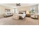 Spacious main bedroom suite with a seating area, ceiling fan, and bright, neutral decor at 21851 E Tallkid Ave, Parker, CO 80138