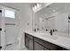 Bathroom featuring double sinks, quartz countertops, and a shower with a white tiled surround at 11902 Octave Ave, Parker, CO 80134