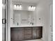 Modern bathroom featuring a double vanity, a large mirror, and a walk-in shower at 11902 Octave Ave, Parker, CO 80134