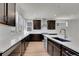 Bright kitchen features dark cabinets, light countertops, stainless appliances, and wood floors at 11902 Octave Ave, Parker, CO 80134
