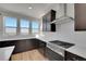 Close-up of kitchen with stainless steel appliances, white backsplash, and dark cabinets at 11902 Octave Ave, Parker, CO 80134